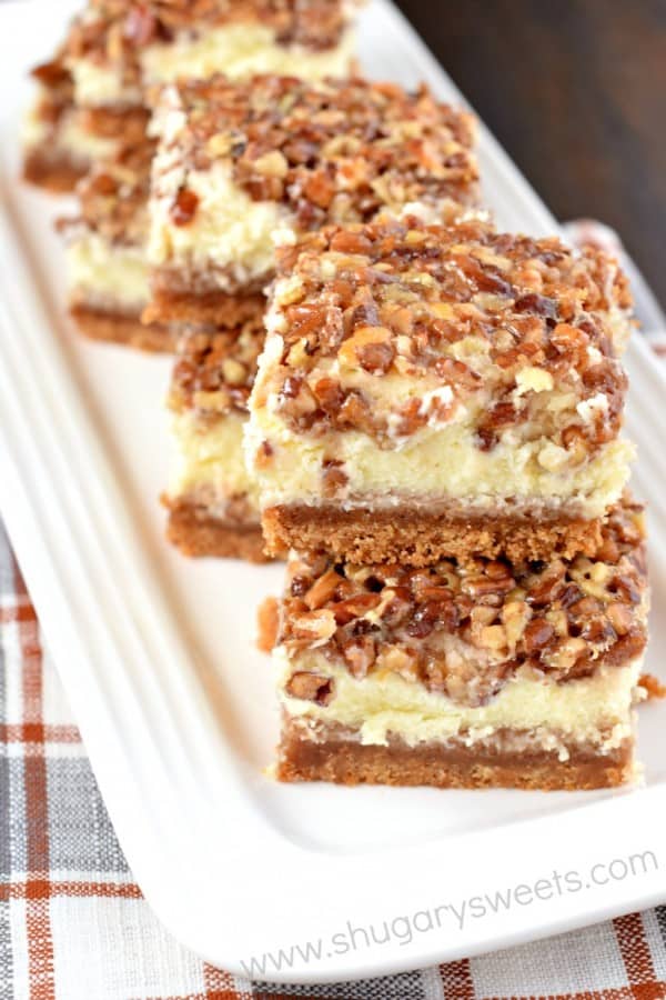 Stack of pecan pie cheesecake bars on a white tray