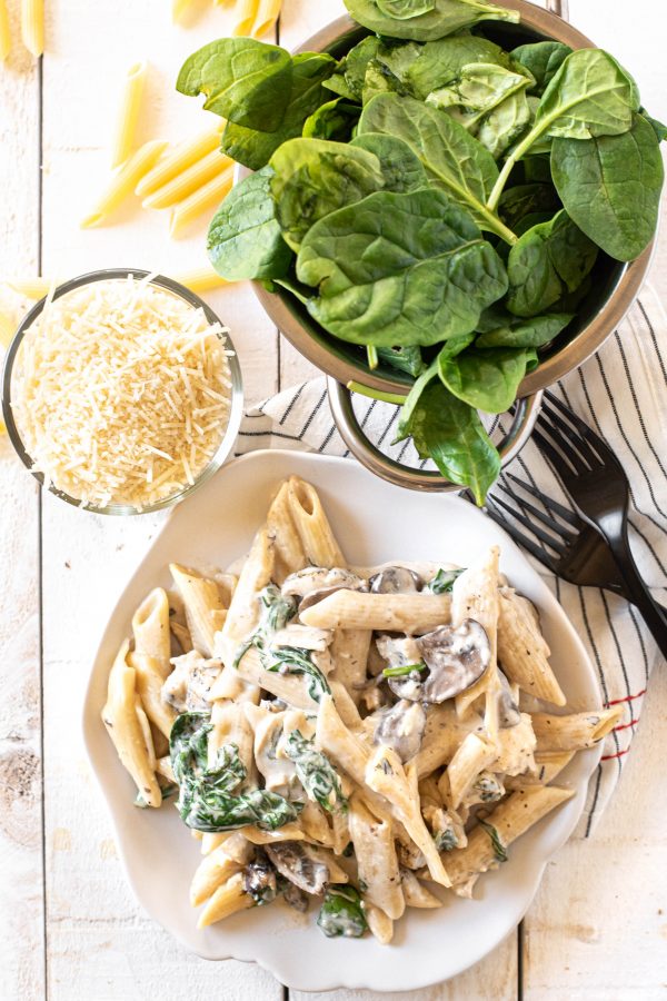 Overhead view of Instant Pot pasta on a plate with cheese and spinach