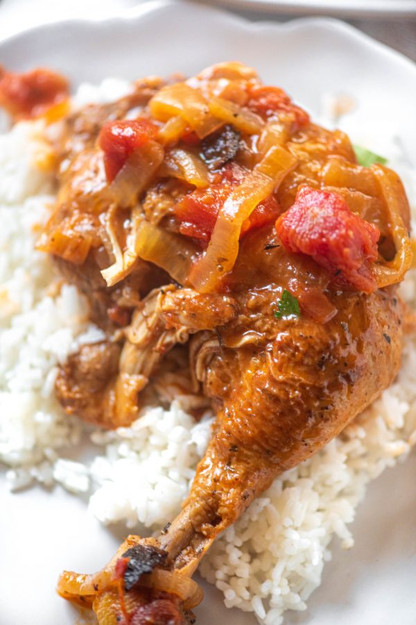 Close up of Instant Pot Chicken Cacciatore over rice on a white plate